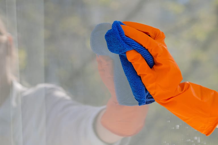 Cleaner washing office windows with a pole in Toronto